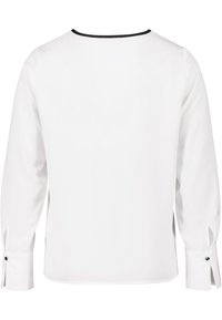 Weiße Longsleeve-Bluse mit rohem Saum, schwarzem Ausschnitt und Knopfdetails an den Manschetten. Glattes Material mit lockerer Passform.