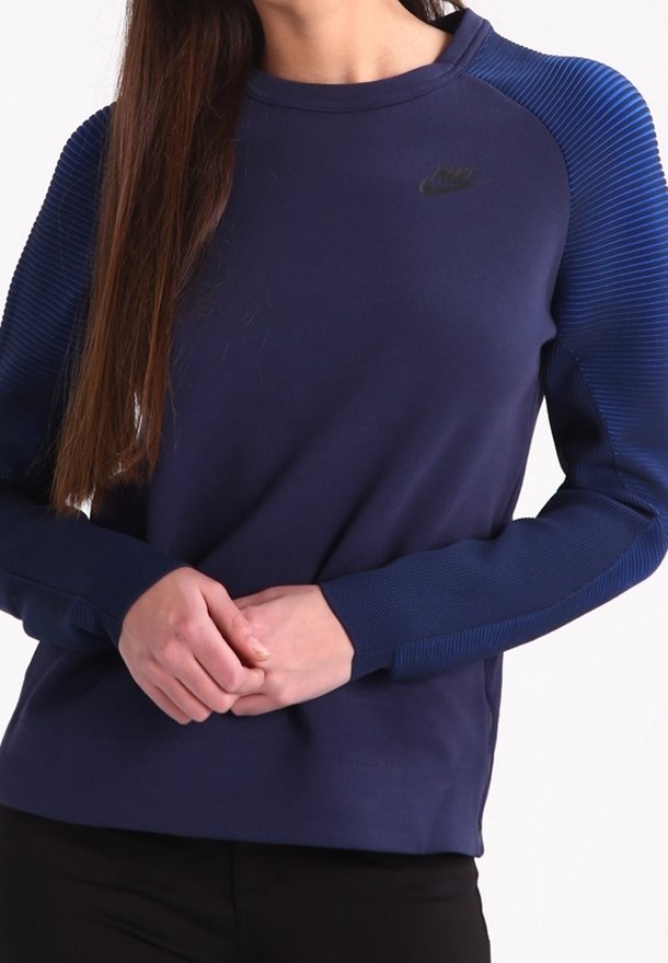 Marinblå Nike-tröja med texturerat randmönster på ärmarna. Har en rund halsringning och en subtil svart logo på bröstet.