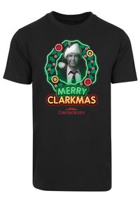 Juodas medvilnės marškinėliai su žalia ir raudona grafika. Tekstas skelbia "LINKSMO CLARKMAS" su centriniu įvaizdžiu šventinėje vainike.