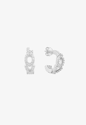 Sølvøreringe med ringform, besat med små klare krystaller, der danner bogstaverne "O" og "V" på forsiden.