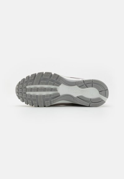 Shoe sole with multi-directional treads, featuring a gray rubber material and a textured surface for grip and traction.