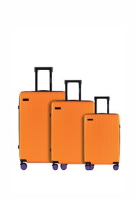 Trzy pomarańczowe walizki z twardą powłoką o różnych rozmiarach, z pionowymi rowkami, czarnymi wysuwanymi rączkami i fioletowymi kółkami.