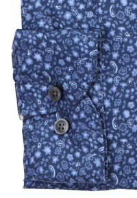 Tessuto blu con un piccolo motivo floreale e paisley, caratterizzato da un polsino con due bottoni, uno scuro e uno grigio chiaro.
