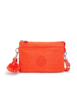 Orange zippered pouch made of lightweight fabric, featuring a round logo, adjustable strap, and a removable furry monkey keychain.
