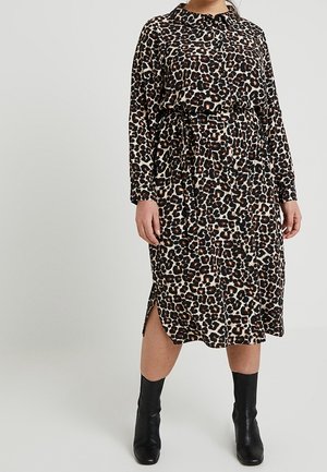 Sukienka w panterkę z długimi rękawami, kołnierzykiem, paskiem w talii i bocznym rozcięciem. Wykonana z miękkiej tkaniny, w kolorach brązowym, czarnym i kremowym.