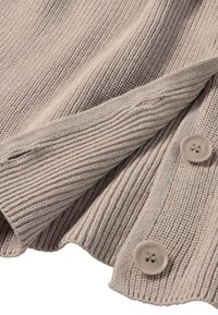 Beige gerippter Strickstoff mit zwei passenden Knöpfen und einem Knopfloch, das die Textur und Details des Garmentrands zeigt.