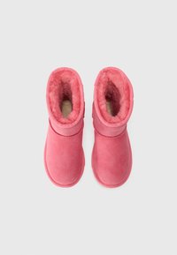 Bottines en suède rose avec une doublure en fourrure douce, bout rond et design à tige courte, présentant des accents de couture horizontale.