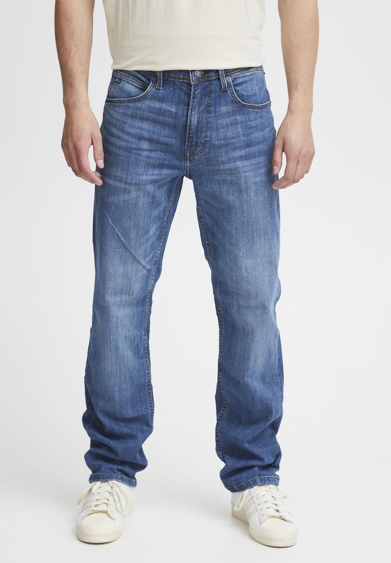 Jeans de mezclilla azul con corte recto, que cuentan con una bragueta con cremallera, diseño de cinco bolsillos y un sutil desgastado para añadir textura.