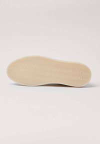 Suola in gomma con un motivo a zig-zag, di colore beige. Forma arrotondata con una finitura liscia e testurizzata e delicata branding sul lato.