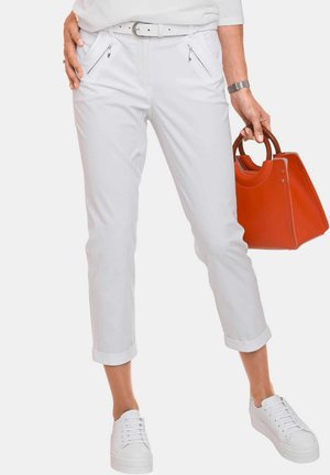 White, lightweight pants with two side zip pockets, cuffed hems, and a smooth texture, paired with a red handbag and white sneakers.
