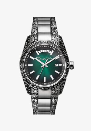 Orologio da polso in acciaio inossidabile con motivi ornamentali, quadrante verde, indici bianchi delle ore, finestrelle per giorno e data e logo Thomas Sabo sul quadrante.