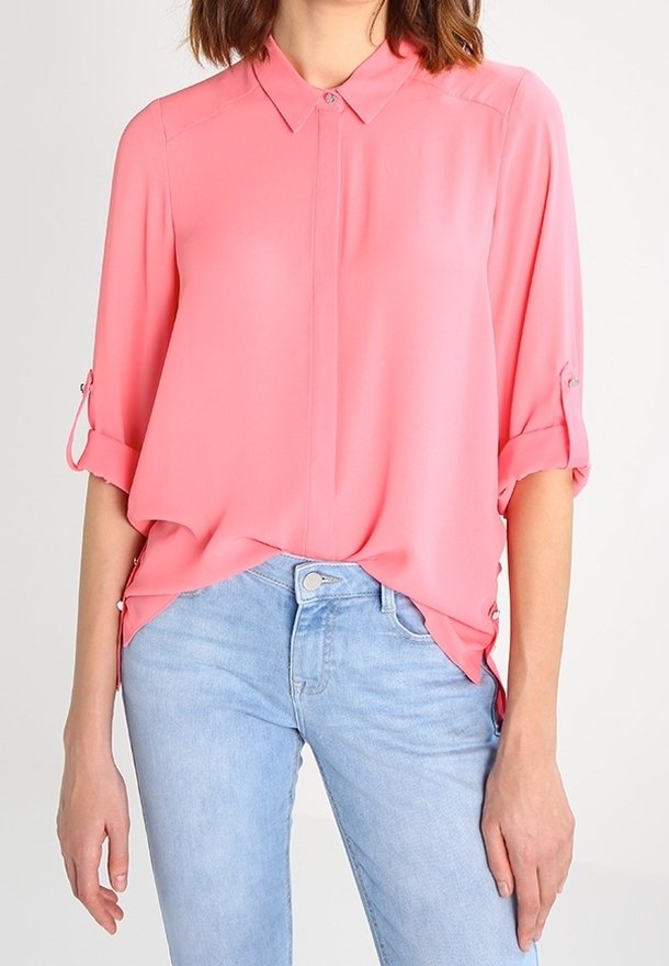Rosa, lätt blus med krage, uppvikta ärmar och lös passform. Matchat med ljusblå denimjeans.