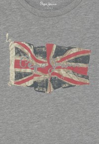 Harmaa puuvillainen t-paita, jossa on kulunut Union Jack -kuvio punaisena, kultaisena ja mustana, ja alla hopeanvärinen teksti "Pepe Jeans London".