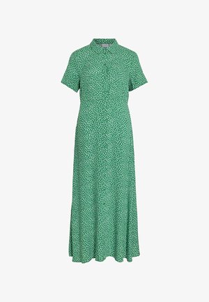 Robe verte à manches courtes, col et boutons sur le devant. Elle présente un motif de pois blancs, fabriquée dans un tissu léger avec un design fluide.