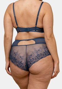 Ensemble de lingerie en dentelle marine avec un dos transparent orné de broderies florales, des bretelles réglables et un détail en forme de trou de serrure.