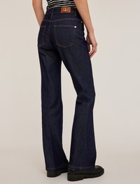 Mörkblå denimjeans med vida ben och hög midja, synliga sömmar, två bakfickor och en brun logotyppatch vid midjan.