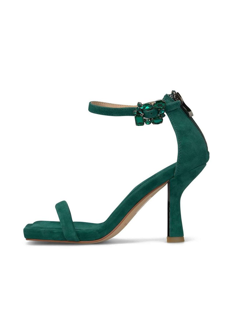 Zielona zamszowa sandał na wysokim obcasie z paskiem wokół kostki, odkrytą palcą i ozdobami. Charakteryzuje się eleganckim wzornictwem i 4-calowym obcasem.