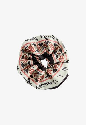 Seidiges Haargummi mit schwarzem, rotem und beigem Blumenmuster und kursivem Text auf dem Stoff, der in einer kreisförmigen Form zusammengefaltet ist.