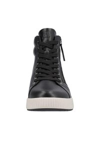 Baskets montantes en cuir noir avec semelle en caoutchouc blanc, présentant un design à lacets, une fermeture éclair latérale en métal et des accents texturés sur la tige.