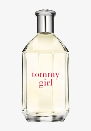Klare Glasparfümflasche mit silbernem Verschluss, hellgelber Flüssigkeit innen und rotem Text "tommy girl" auf der Vorderseite.