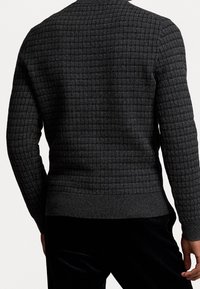 Pull en maille gris foncé avec un motif en grille texturé, doté d'un ourlet et de poignets ajustés. Le matériau semble doux et côtelé.