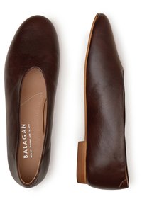 Ballerine in pelle marrone con punta arrotondata e tacco basso in legno. Presentano una texture liscia e dettagli di cucitura discreti.