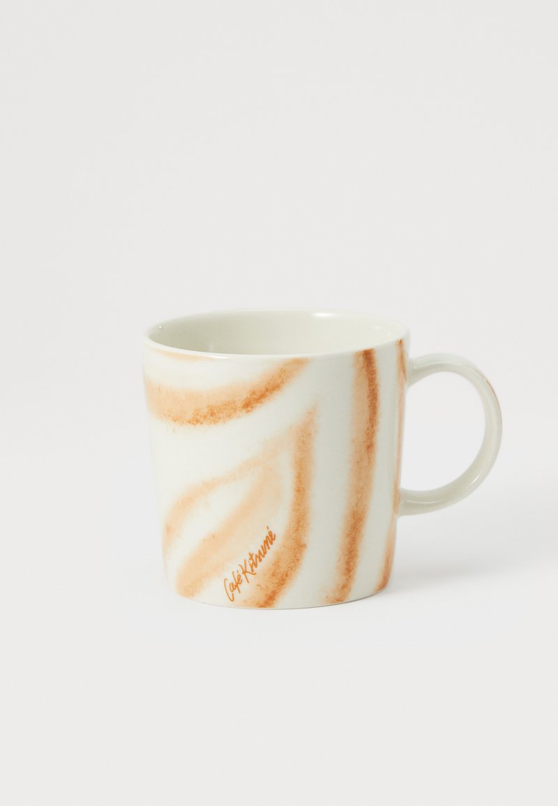 Keramický hrnček s bielym podkladom a oranžovým špirálovým vzorom. Má zaoblený tvar a pevné držadlo, s nápisom "Café Ktummi" vytlačeným oranžovou farbou.