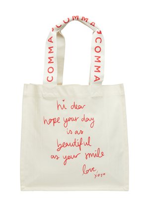 Kremowa torba na ramię z czerwonym, odręcznym napisem życzącym pięknego dnia i uśmiechu oraz kremowe uchwyty z nadrukiem "COMMA" w kolorze czerwonym.