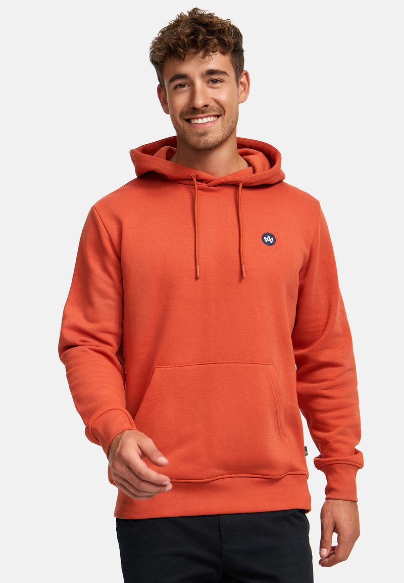 Sudadera naranja hecha de material suave, con un bolsillo frontal, capucha con cordones y un pequeño logo azul marino en el pecho. Tejido texturizado.