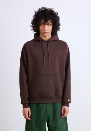 Brown hoodie with a front pocket, drawstring hood, and ribbed cuffs. Made of soft fabric; features a small gold logo on the left sleeve.