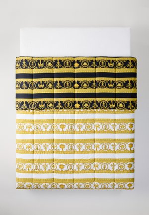 Quilted bedding with a black and gold patterned top section, and a white and gold patterned lower section featuring intricate designs.