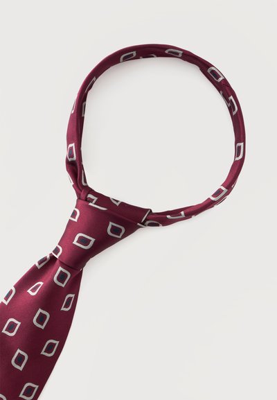 Cravate bordeaux avec des motifs géométriques carrés blancs et noirs nouée en un nœud sur un fond blanc.