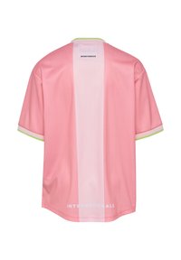 Różowy sportowy T-shirt z krótkim rękawem, z białą pionową paskiem i zielonym akcentem przy kołnierzyku, na plecach z nadrukiem "INTERNATIONALS" w białym kolorze.