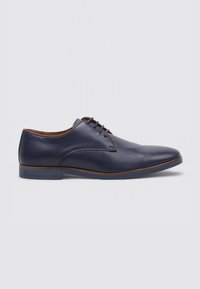 Chaussure lacée en cuir bleu marine avec un bout pointu, texture lisse, accents marron le long de la semelle et un design minimaliste.