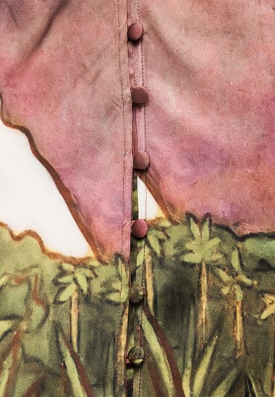 Πουκάμισο με κουμπιά, με εκτύπωση σε υδατοχρώματα σε ροζ και πράσινους τόνους, υφή από ομαλό ύφασμα και στρογγυλά κουμπιά καλυμμένα με ύφασμα.