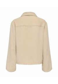 Veste beige à manches longues avec un large col, tissu texturé et un ourlet droit, vue de dos sur un fond blanc.