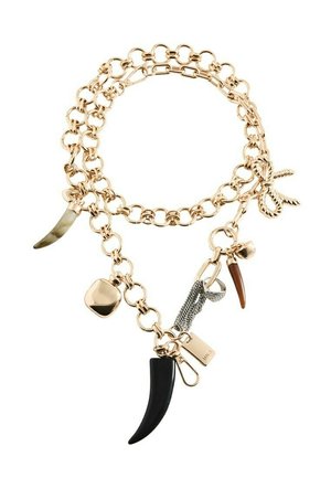 Bracciale con catena in tono oro con vari ciondoli, tra cui pendenti a forma di corno neri e marroni, un piccolo lucchetto dorato e un dettaglio a nodo di corda.
