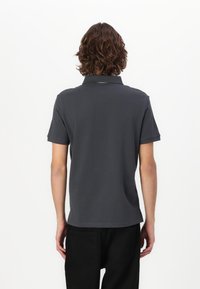 Polo de culoare gri închis, din bumbac, cu mâneci scurte, guler clasic și tiv drept. Design minimalist, fără modele notabile.