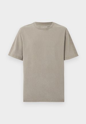 Enkelt beige T-shirt med korte ærmer, rund hals og synlige sømme, vist på en hvid baggrund.