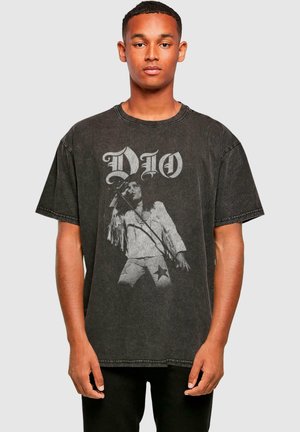 Black oversized t-shirt made of cotton with a faded graphic print of a performer and large "DIO" text in white. Short sleeves and crew neckline.