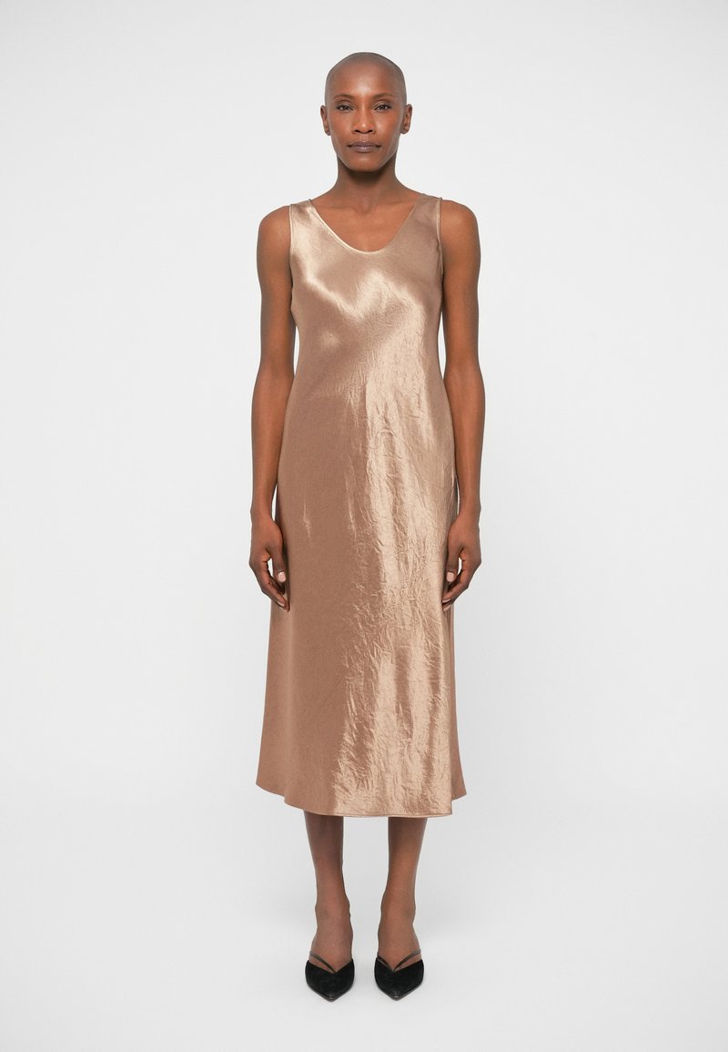 Σατέν μεσάτη φόρεμα σε ήπιους καφέ τόνους με λεία υφή, δι�αθέτοντας V-λαιμόκοψη και ρυθμιζόμενα λεπτά λουράκια.