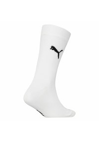 Vit träningssocka i medelhög längd, tillverkad av mjukt och elastiskt material. Har en svart Puma-logotyp stickad på sidan.