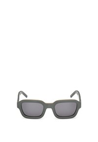 Harmaat aurinkolasit, joissa on neliömäinen kehys, tummilla tummennetuilla linsseillä ja kultaisilla yksityiskohdilla yläreunassa. Matte pintakäsittely kehys.