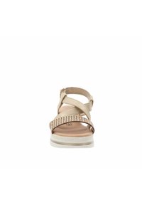 Sandale beige avec des sangles croisées, design perforé, bride de cheville ajustable et semelle texturée blanche pour une meilleure traction.