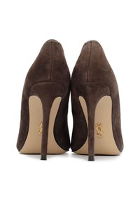 Scarpe con tacco alto in suede marrone, con punta affusolata, caratterizzate da un accento con logo dorato sulla suola e da un design elegante del tacco a stiletto.