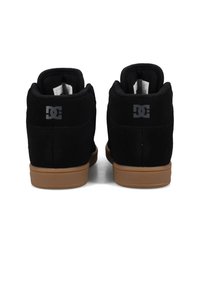 Černé semišové vysoké tenisky s gumovou podrážkou. Obsahují jemné logo DC na patě a polstrovaný límec pro podporu.