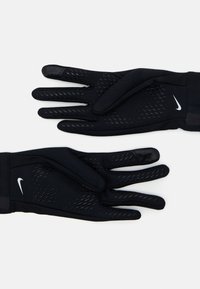 Guantes negros hechos de tela texturizada con un patrón de agarre de silicona en las palmas. Presenta un logotipo en la muñeca. Puño elástico para un ajuste seguro.