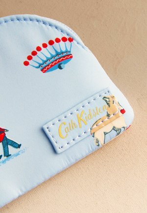 Material albastru deschis cu ilustrație de coroană roșie și albastră, imprimeu mic cu câine și etichetă cusută pe care scrie "Cath Kidston".