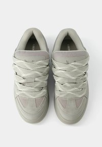 Hellgraue Sneakers mit strukturiertem Stoff und glatten Einsätzen, breiten Schnürsenkeln und gepolstertem Kragen. Abgerunderte Zehenpartie und schlichtes Design.