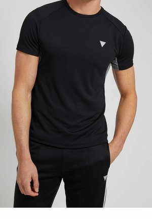 T-shirt de sport noir à manches courtes, avec un logo triangulaire et des accents en panneaux latéraux gris. Tissu lisse et extensible, coupe ajustée.